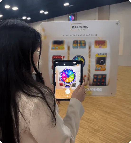 Attendee using the AR experience on a phone in front of a Backdrop Alive booth