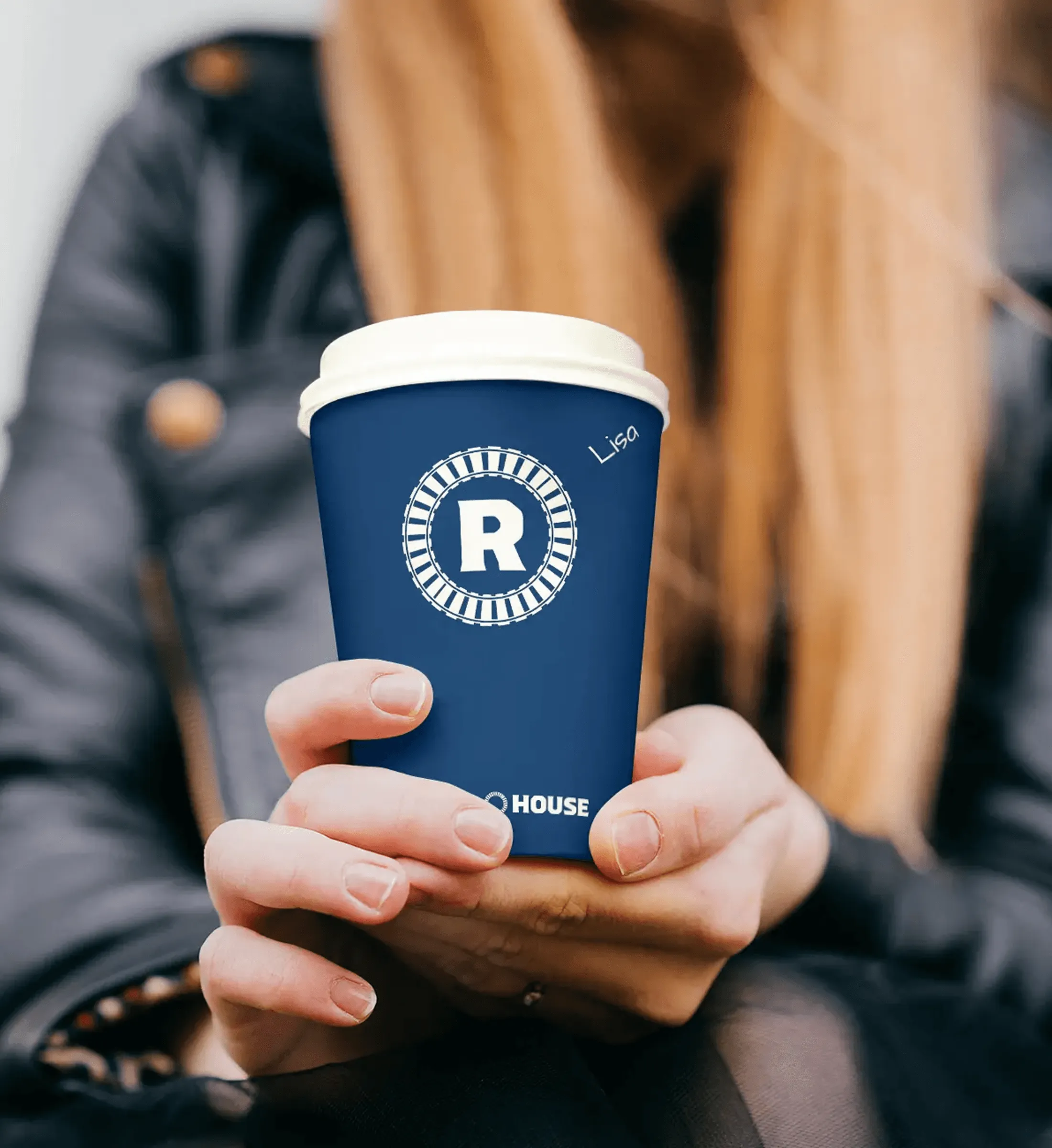 Person holding a navy Roundhouse coffee cup