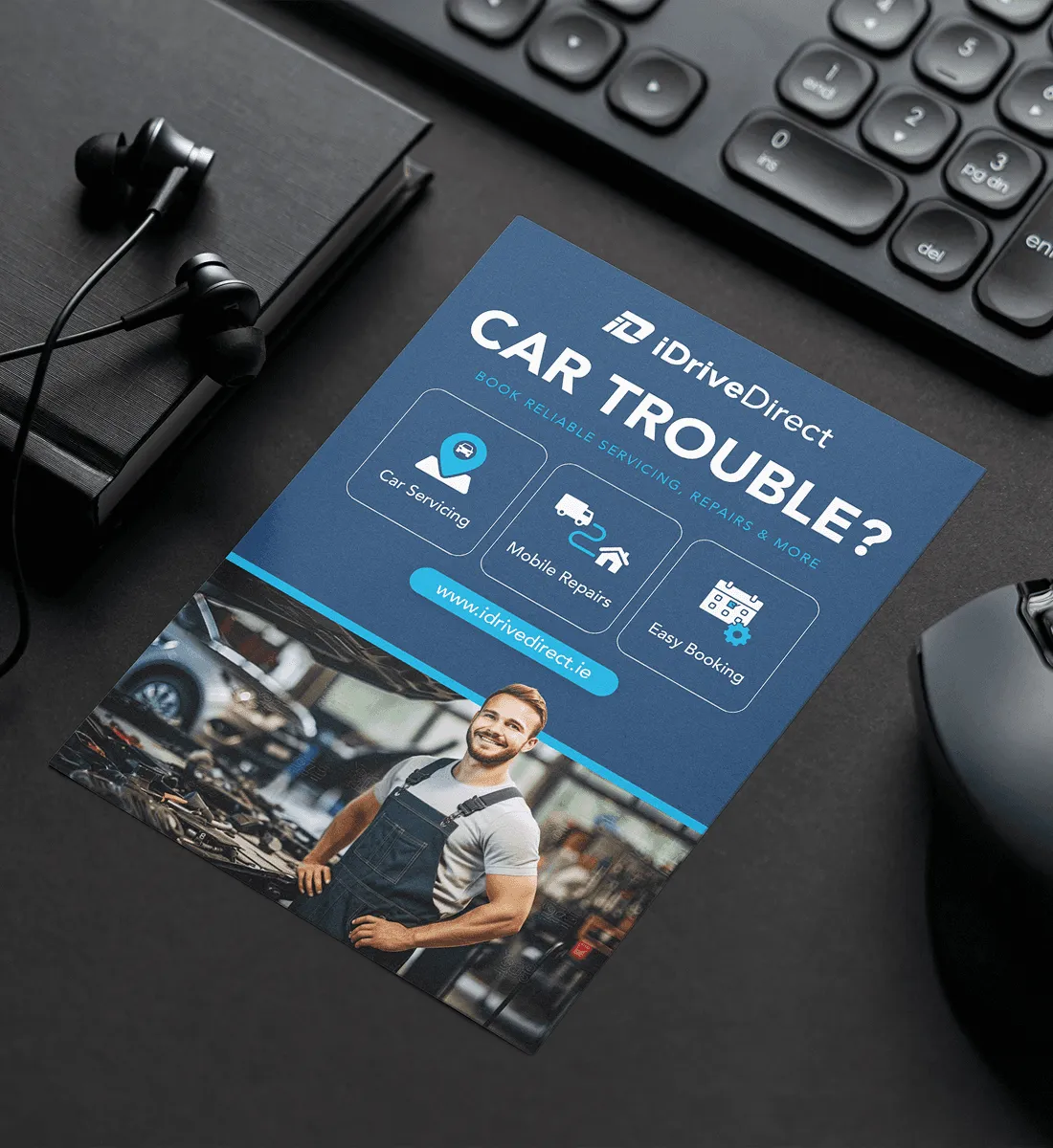 iDriveDirect “Car trouble?” flyer on a desk next to a keyboard