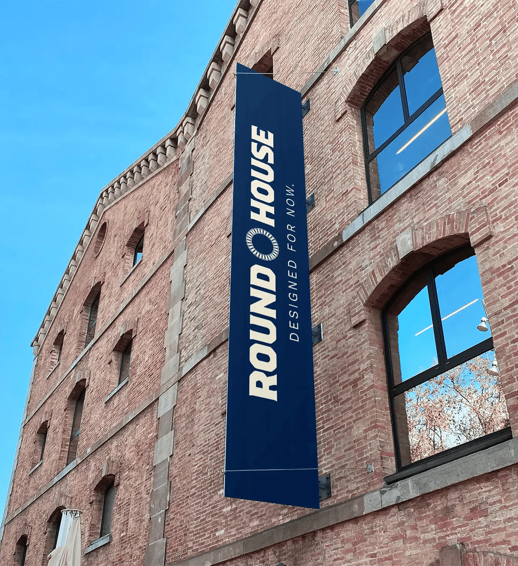 Vertical navy Roundhouse banner on the side of a brick building