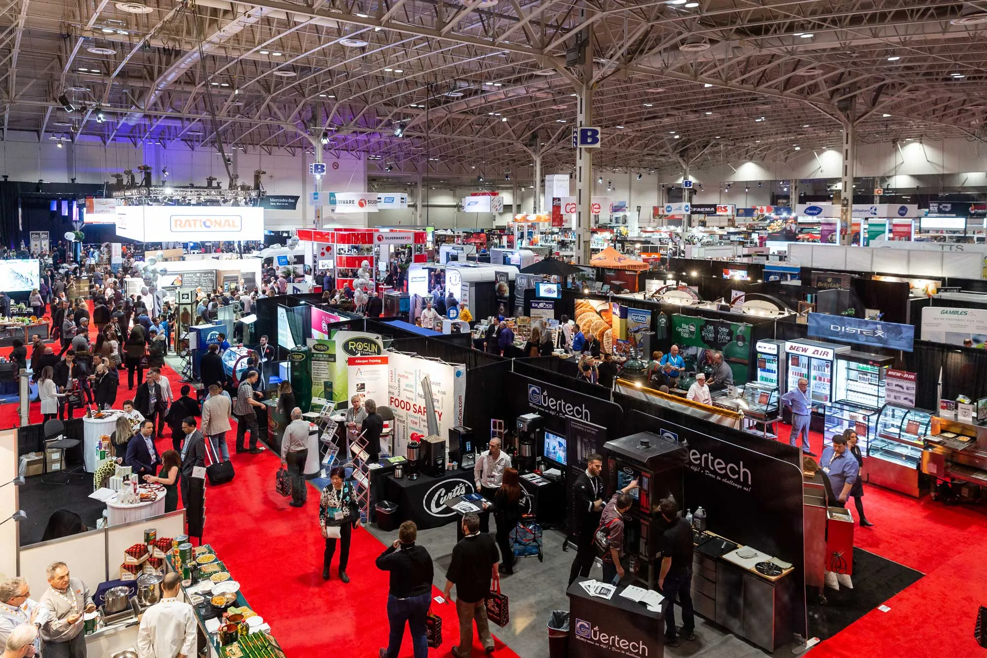 Busy trade show floor with rows of exhibitor booths